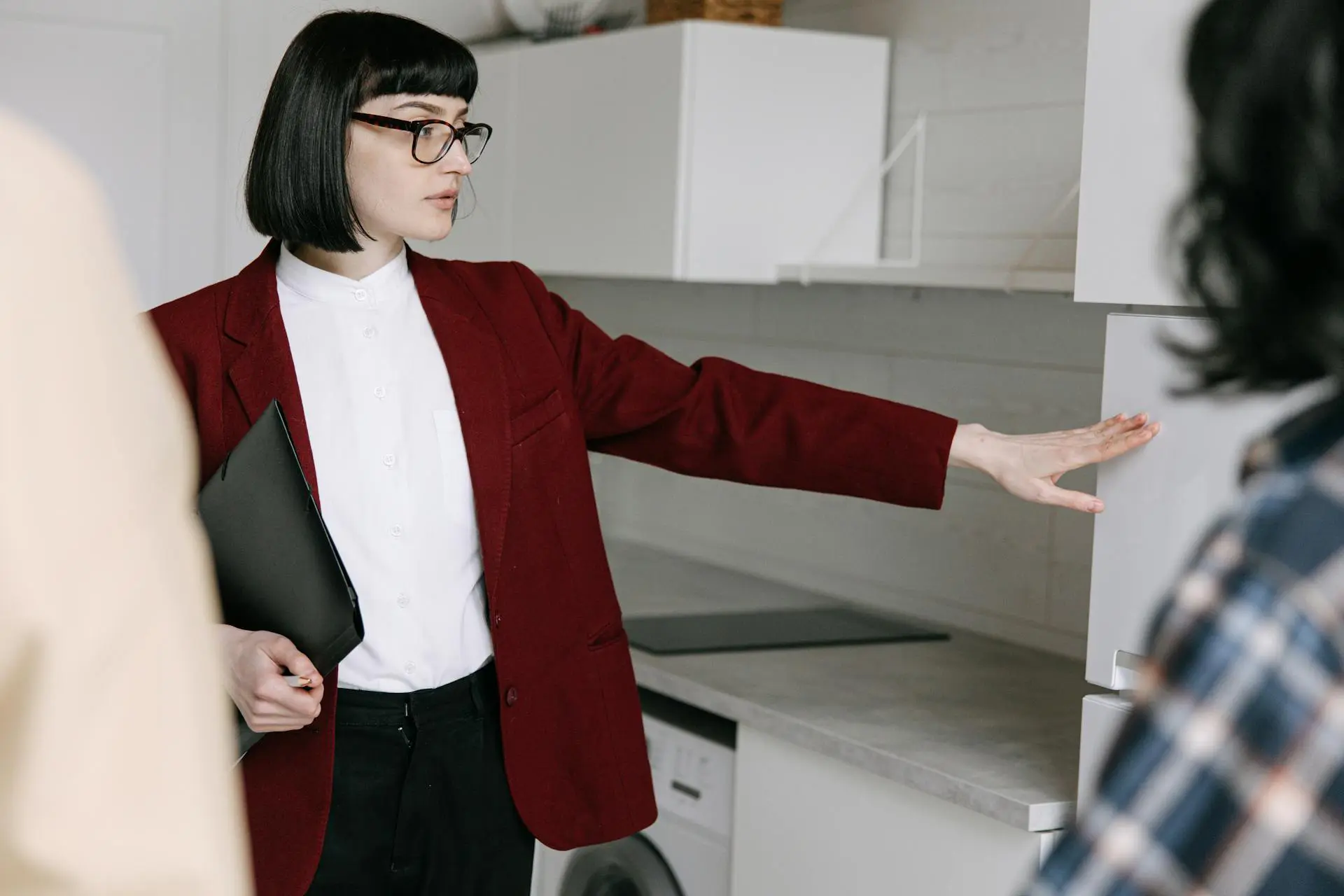 Person showing kitchen space to clients.