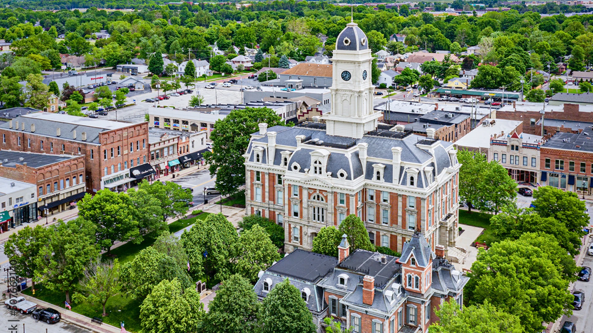 Historic courthouse surrounded by trees and buildings.